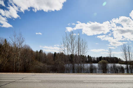 High water on a river or on a lake in sunny spring day. Russian nature landscape with water, trees...