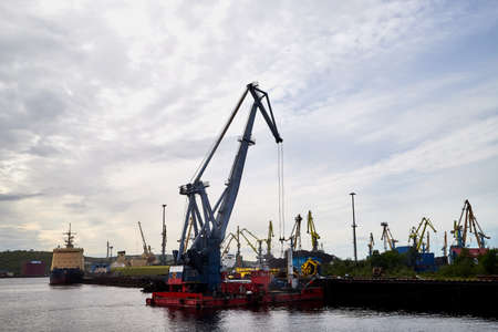 Murmansk, Russia - June 21, 2019: Cranes in the port and the sky with clouds in the evening or in...