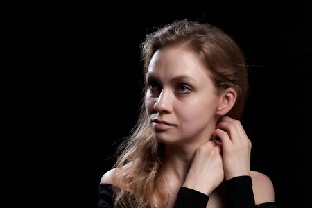 Beautiful gentle girl with long blonde hair on a dark background. Romantic portrait in Renaissance styleの写真素材