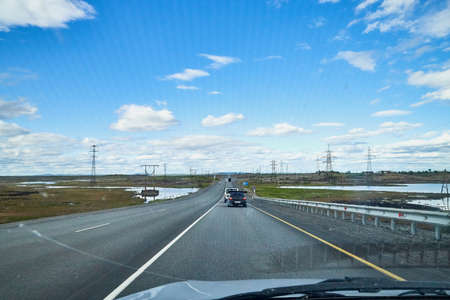 Murmansk, Russia - June 20, 2019: View from car windscreen to highway, tundra and blue sky in evening timeのeditorial素材