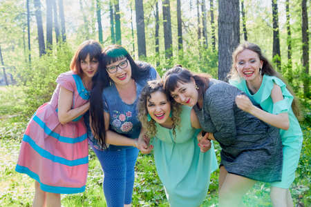 Group of female friends walking in summer or spring park. Women and adult girl have fun together outdoorのeditorial素材