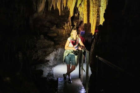 Kutaisi, Georgia - October 24, 2019: Tourists in beautiful colorful and illuminated cave with stalactites and stalagmites and black backgroundのeditorial素材