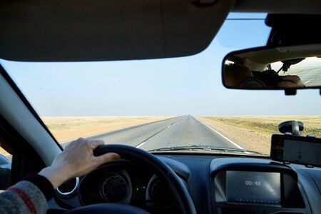 View from car window on the road and landscape with steppe, prairie, wilderness, plain and blue sky....