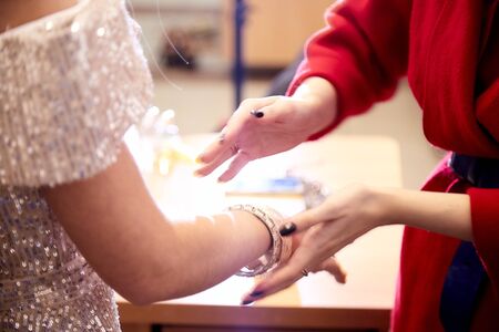 Two female friends try on jewelry in the room. Ring on a hand of a girlの写真素材