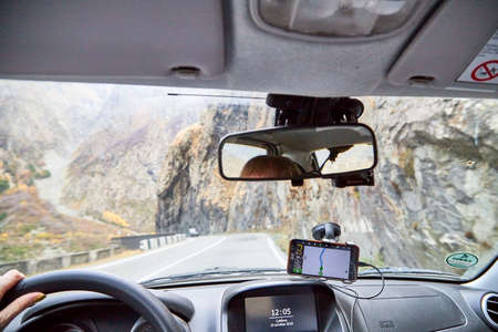 Tbilisi, Georgia - October 19, 2019: View from inside car window to the road and autumn mountain landscape. Asphalt road in perspective in a sunny day. Concept alone travel to nature during covid-19のeditorial素材