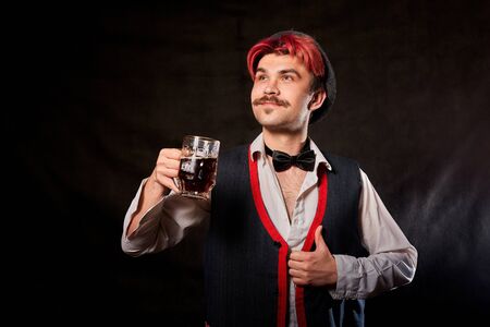 Portrait of Oktoberfest funny young man or guy in traditional national ethnic clothes and hat with...