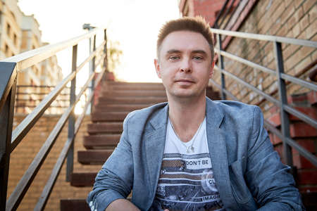 Kirov, Russia - September 04, 2019: Portrait of a handsome fun smiling young man outdoors in the street of the city in a summer, spring or autumn dayのeditorial素材