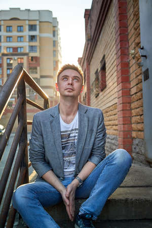 Kirov, Russia - September 04, 2019: Portrait of a handsome fun smiling young man outdoors in the street of the city in a summer, spring or autumn dayのeditorial素材