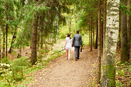 Kirov, Russia - September 08, 2019: People walking on Small old pathway in a forest or a park with yellow and green trees at autumn day. Nature lanscape and concept of a healthy lifestyleのeditorial素材