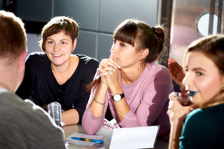 Kirov, Russia - September 25, 2019: People at table in small cafe or restaurant during intellectual game. Hungry group waiting for the waiter to get the menu or foodのeditorial素材
