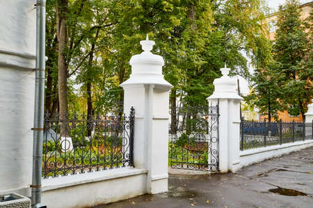 Decorative fence of columns on alley in park and green trees on backgroundのeditorial素材
