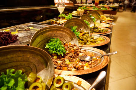 Food on the shelves in the self-service buffet with all inclusive and people in the hotel in Turkey