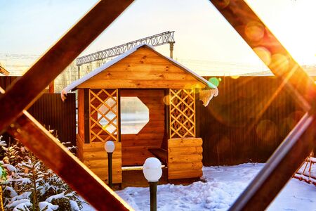 Yellow wooden gazebo in the yard on a Sunny winter day with blue skyの写真素材