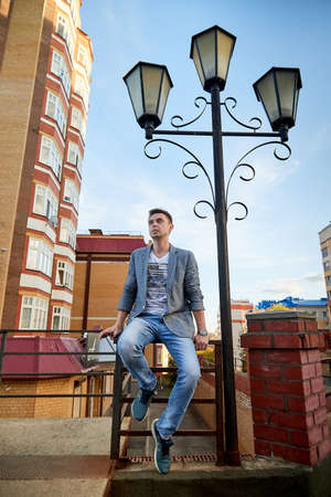 Kirov, Russia - September 04, 2019: Portrait of a handsome fun smiling young man outdoors in the street of the city in a summer, spring or autumn dayのeditorial素材