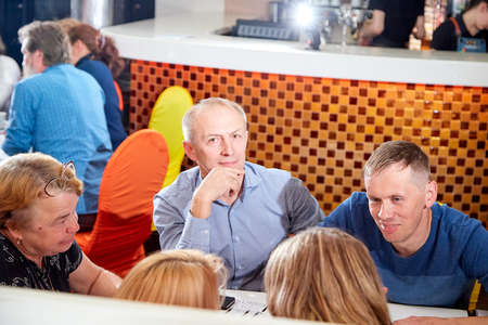 Kirov, Russia - October, 2019: People at table in small cafe or restaurant during intellectual game....