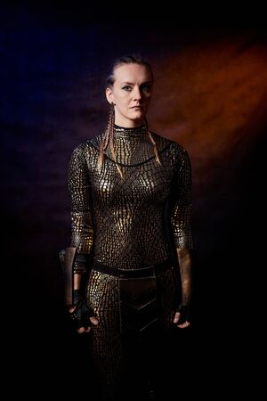 Valkyrie girl in shiny military armor in a dark room. Model during a photo shoot, the actress during the shooting of the filmの写真素材