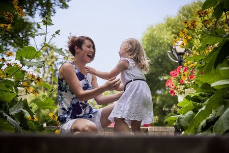 Happy mother and daughter in the park. Family resting and having fun outdoor. Beauty nature scene with family outdoor lifestyle.の写真素材