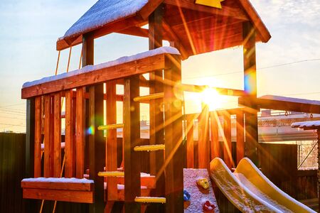 Yellow wooden gazebo in the yard on a Sunny winter day with blue sky