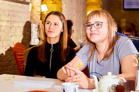 Kirov, Russia - September 17, 2019: People at table in small cafe or restaurant during intellectual game. Hungry group waiting for the waiter to get the menu or foodのeditorial素材