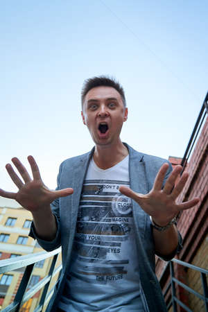 Kirov, Russia - September 04, 2019: Portrait of a handsome fun smiling young man outdoors in the street of the city in a summer, spring or autumn dayのeditorial素材
