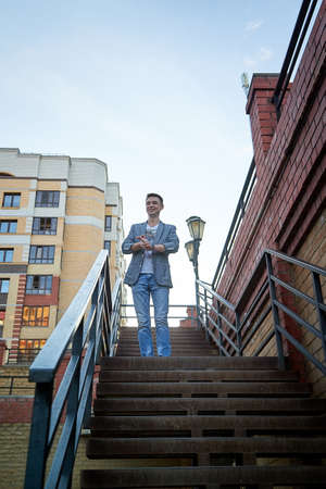 Kirov, Russia - September 04, 2019: Portrait of a handsome fun smiling young man outdoors in the street of the city in a summer, spring or autumn dayのeditorial素材