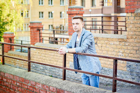 Kirov, Russia - September 04, 2019: Portrait of a handsome fun smiling young man outdoors in the street of the city in a summer, spring or autumn dayのeditorial素材