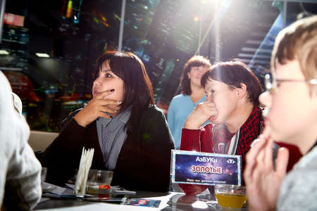 Kirov, Russia - September 25, 2019: People at table in small cafe or restaurant during intellectual game. Hungry group waiting for the waiter to get the menu or foodのeditorial素材