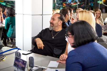 Kirov, Russia - September 25, 2019: People at table in small cafe or restaurant during intellectual game. Hungry group waiting for the waiter to get the menu or foodのeditorial素材