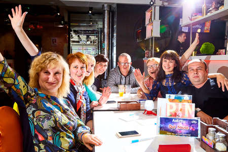 Kirov, Russia - September 17, 2019: People at table in small cafe or restaurant during intellectual game. Hungry group waiting for the waiter to get the menu or foodのeditorial素材