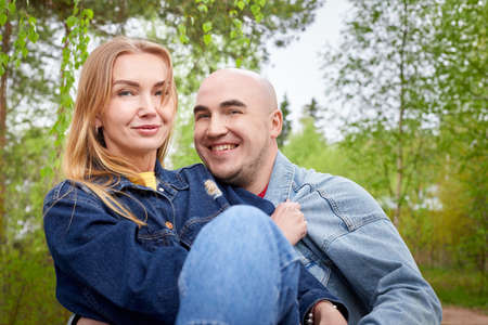 Kirov, Russia - June 22, 2020: European couple of blonde woman and bald man walking at park, enjoying themselves and being happy together. Love and tenderness. Lovers on date outdoors at natureのeditorial素材