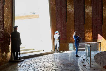 Volgograd, Russia - October 18, 2019: Tourists in Hall of Military Glory in Memorial complex Mamayev Kurgan. Sculpture of hand holding torch with Eternal Fire. Eternal Fire is guarded by soldiersのeditorial素材