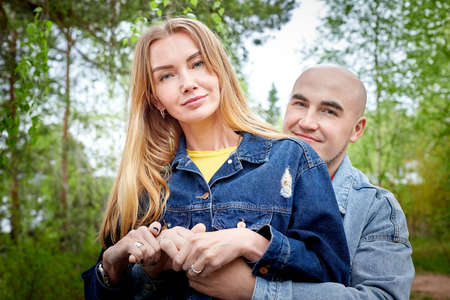 Kirov, Russia - June 22, 2020: European couple of blonde woman and bald man walking at park, enjoying themselves and being happy together. Love and tenderness concept. Lovers on date outdoorsのeditorial素材