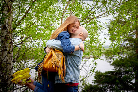 Kirov, Russia - June 22, 2020: European couple of blonde woman and bald man walking at park, enjoying and being happy together. Love and tenderness concept. Lovers on date outdoors at natureのeditorial素材