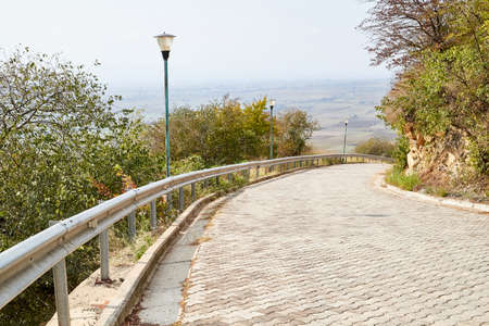 Beautiful landscape with empty old small road in the mountains in a summer or autumn dayの写真素材