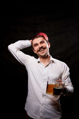 Young handsome guy with red hair in white shirt drinking beer. Funny man with emotions on the face...