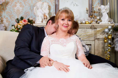 Bride, big fat groom and them teenager son in a nice room with Christmas decoration in a wedding dayのeditorial素材