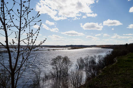 High water on a river or on a lake in sunny spring day. Russian nature landscape with water, trees...