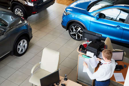 Vologda, Russia - June 18, 2019: Manager in showroom with cars of dealership Nissan in Vologda city...