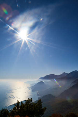 Magnificent view of the mountain at sunset sun-lit bay. Calm sea and mountains in a light haze in Antalya at Turkey