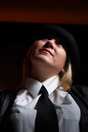 Portrait of fat plump chubby middle-aged woman with hat. Model posing in male style in the Studio.の写真素材