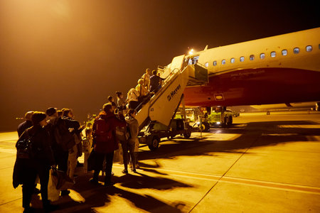 Antalya, Russia - December 21, 2019: People get on the plane at night time with nice light