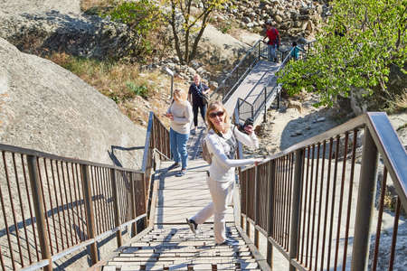 Uplistsikhe, Georgia - October 22, 2020: Tourists in a mountain reserve near ancient old city with...