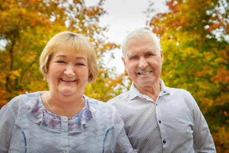 Elderly couple walking in the park on an autumn dayの写真素材