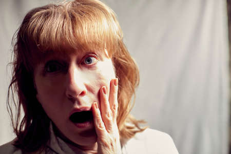Portrait of perplexed puzzled middle-aged woman on a white background. Unprofessional female model...