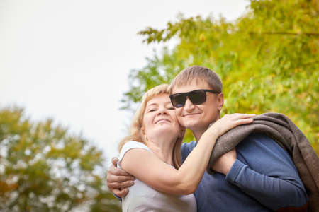 Middle-aged couple walking in the park on an autumn day