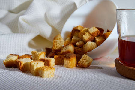 Square toasted pieces of homemade delicious rusk, hardtack, Dryasdust, zwieback on a plate and black...