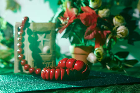 Red beads lying on the table, red flowers and notebookの写真素材