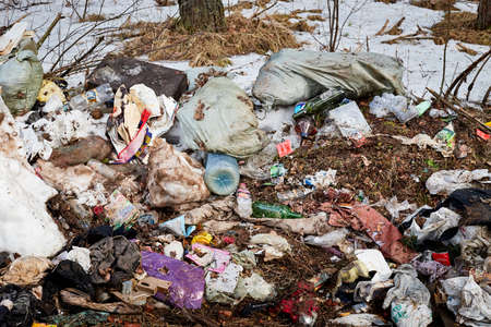 Kirov, Russia - March 29, 2020: Garbage dump in forest spring or winter time and snow with trees backgroundのeditorial素材