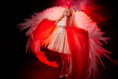 Beautiful blonde girl with curly hair and white wings looks like an nice angel