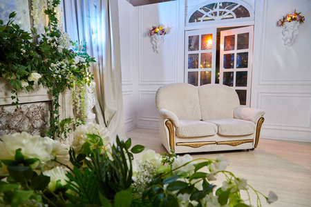 Living room with beautiful interior, sofa and flowers
